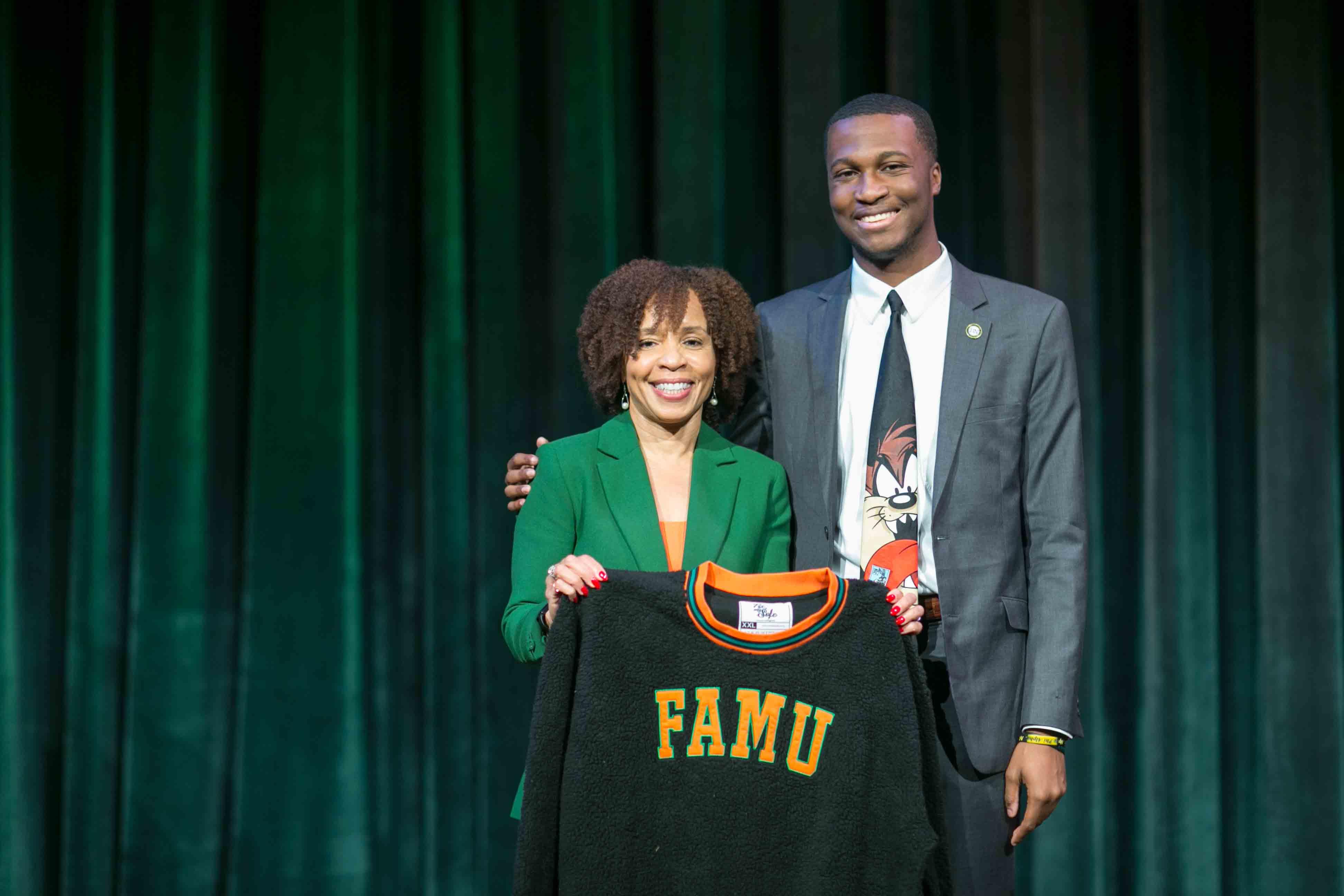 Alumna and Former President of ABC News Kim Godwin with Graphic Communication Alumnus Elijah Rutland holds his custom-designed FAMU sweater.