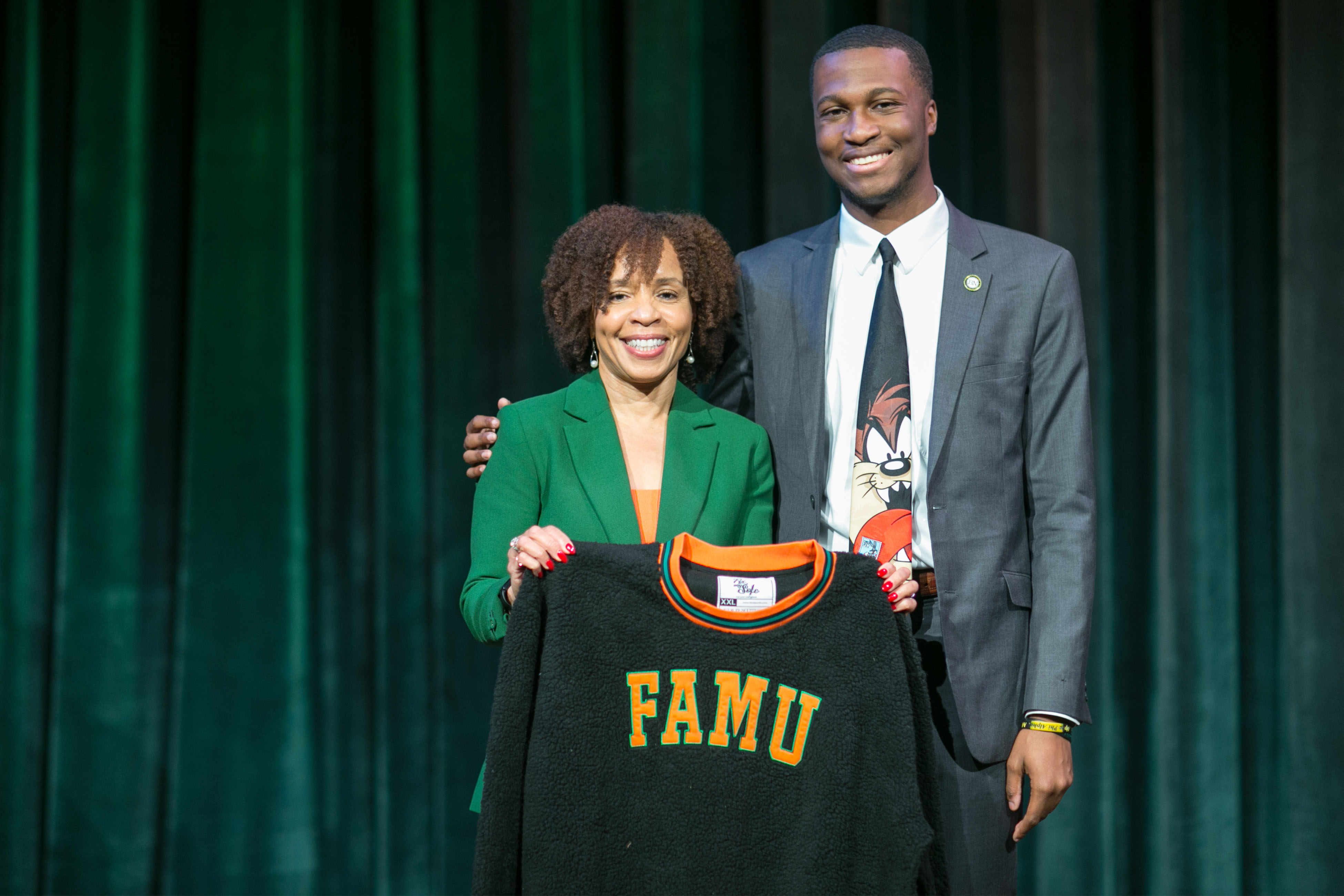 Alumna and President of ABC News Kim Godwin with Graphic Communication Alumnus Elijah Rutland hold his custom designed FAMU sweater.