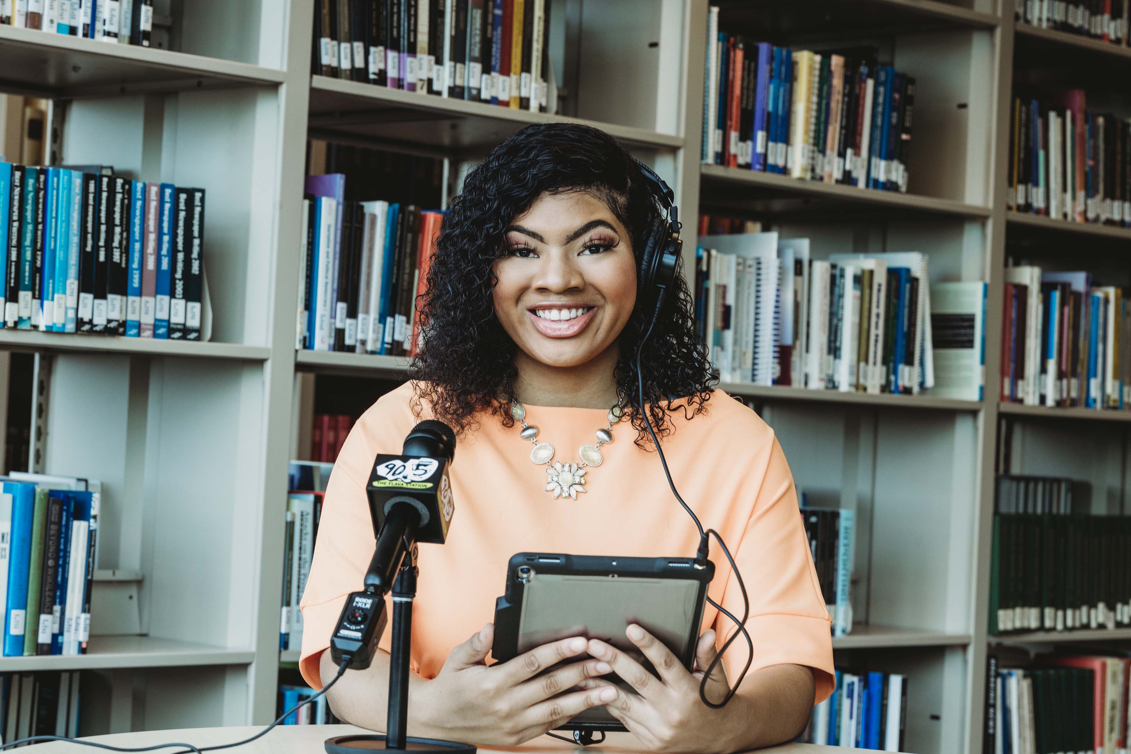 Broadcast Journalism Student conducting podcast using her iPad in the School of Journalism & Graphic Communication Library.