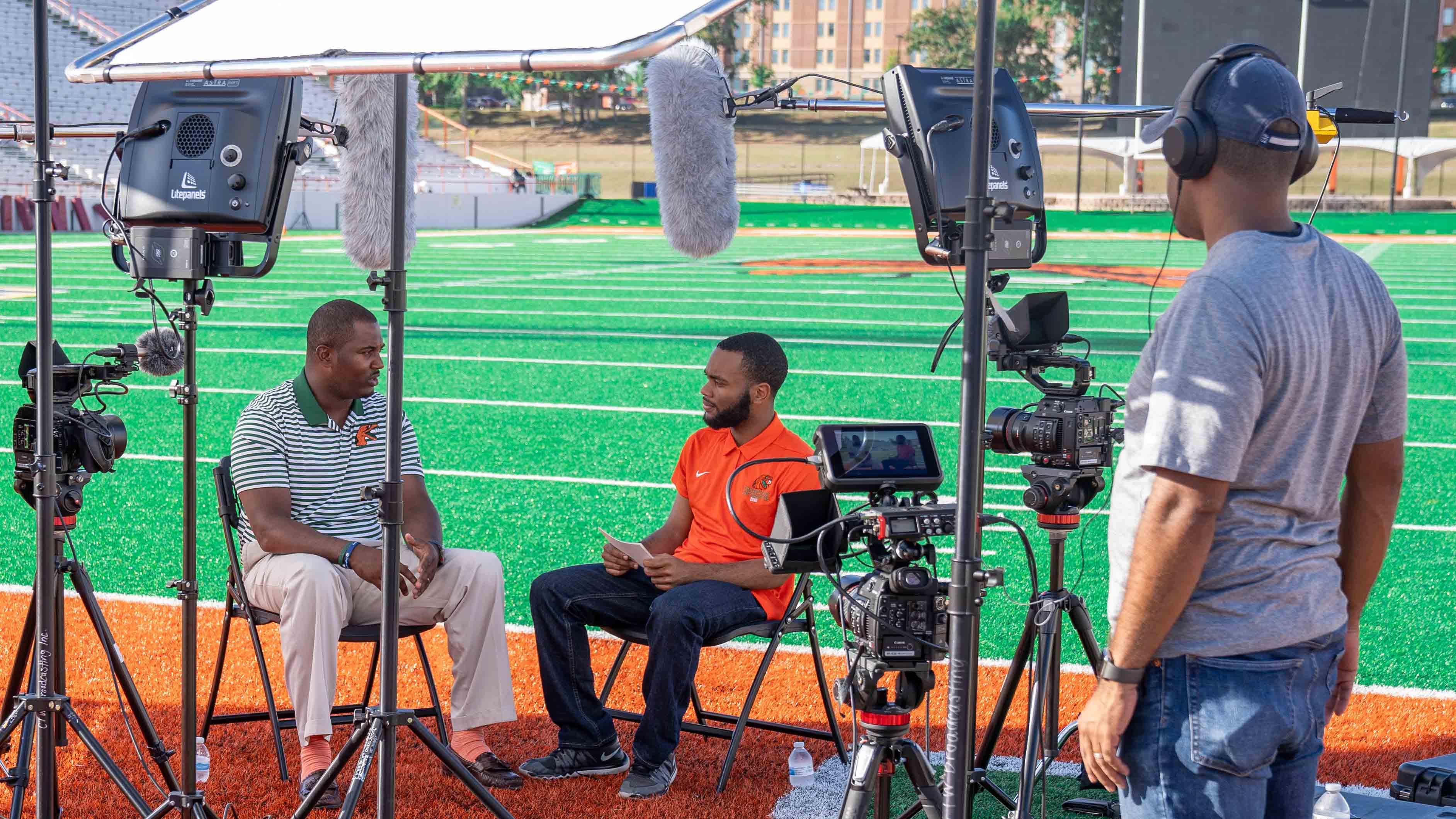 Journalism Student interviewing Former Head Football Coach Willie Simmons on location.