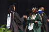 Dean Lowe celebrates with an SJGC graduate as they walk across the commencement stage.