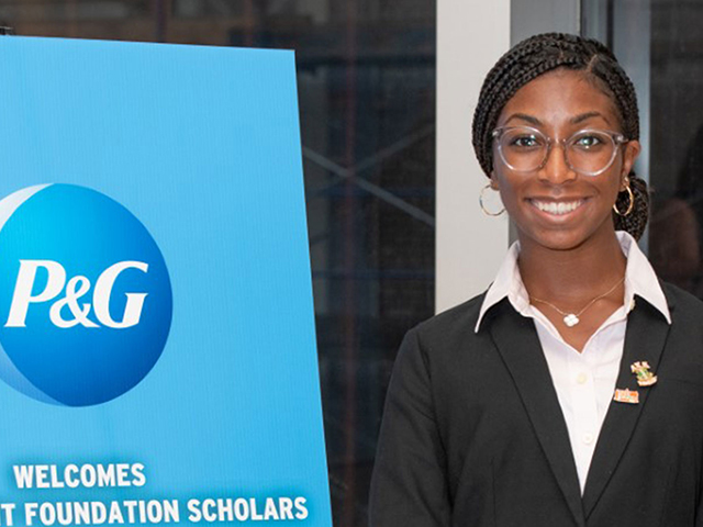 Student posing with P&G sign